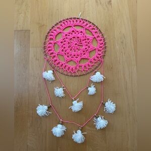 Handmade crocheted dream catcher with pom poms.